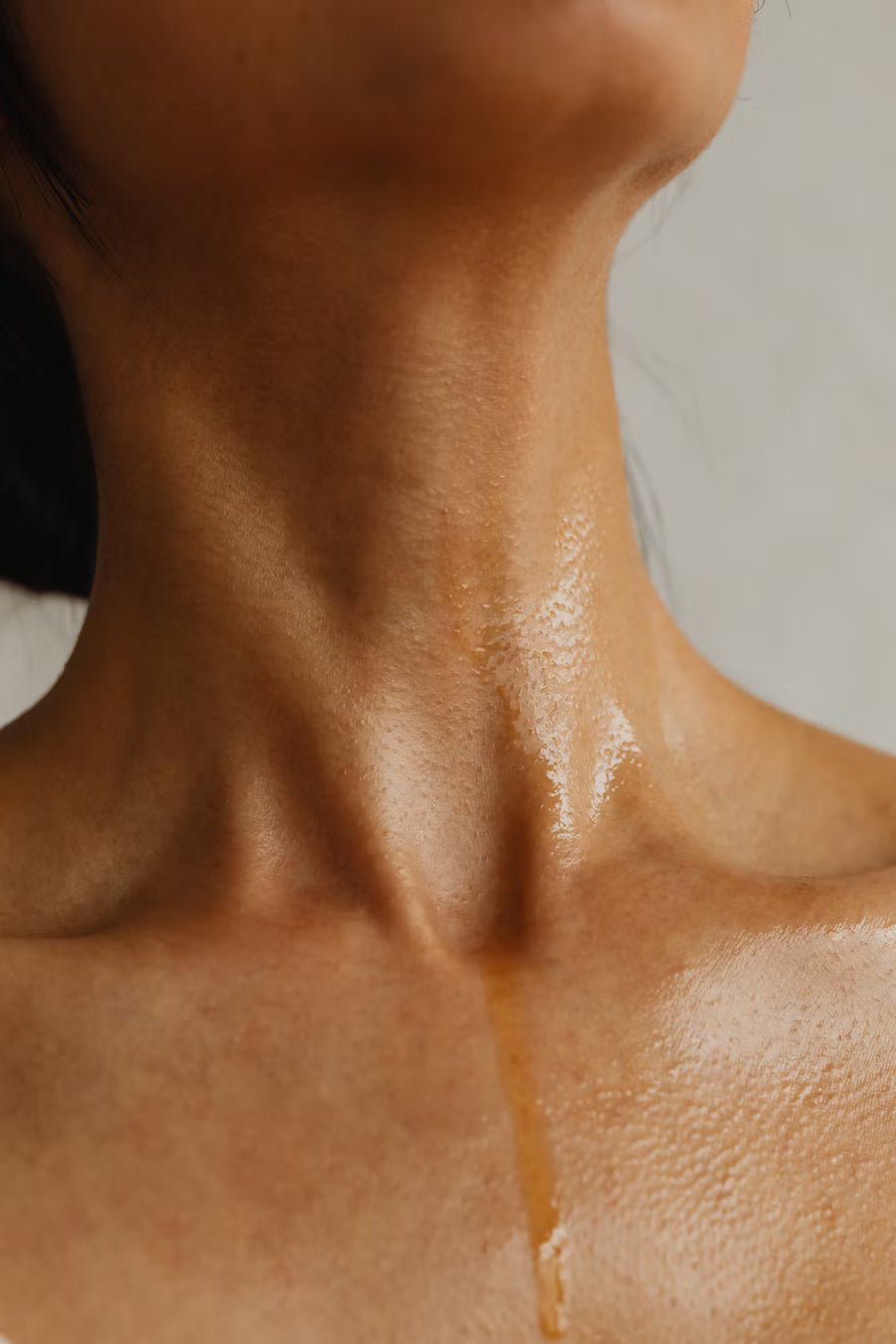 Close-up of a person's neck and shoulders with a neutral background StillMind